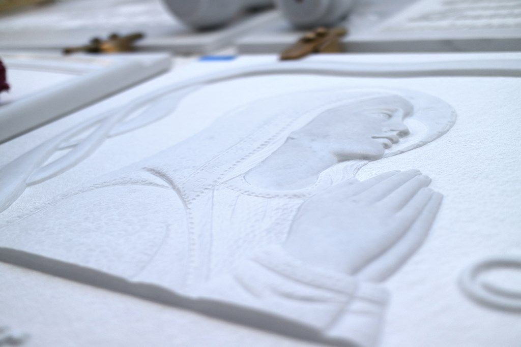 Una statua di una donna con le mani giunte in preghiera