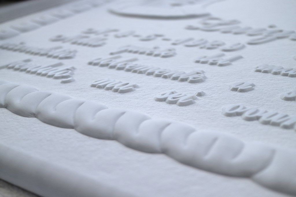 Un primo piano di una targa bianca con alcune parole su di essa