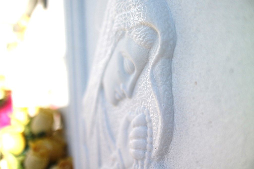 Un primo piano di una statua di Gesù su una tomba.