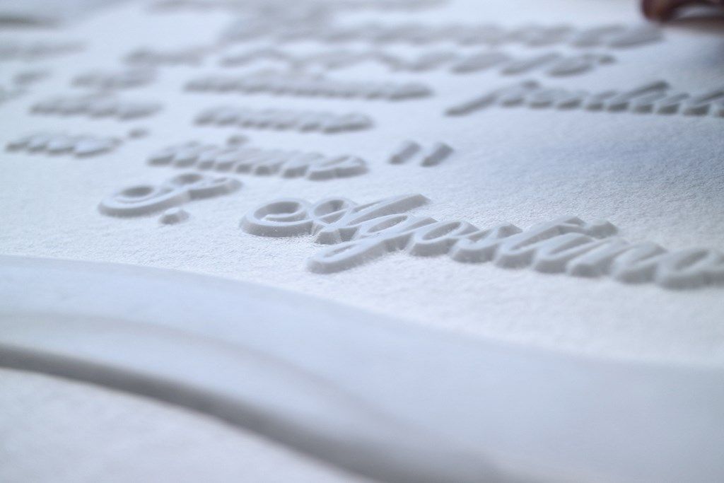 Un primo piano di una superficie bianca con alcune lettere su di essa