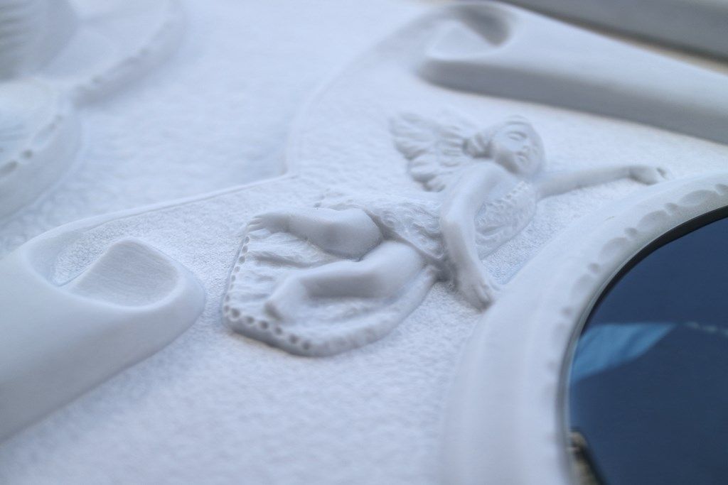 Uno specchio bianco con una statua di un angelo sopra