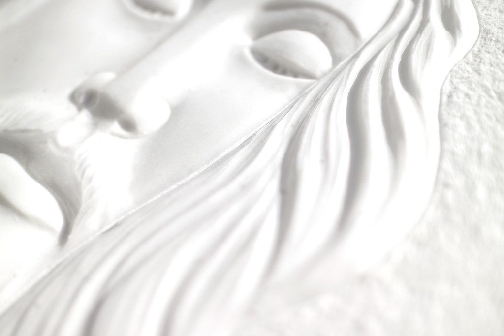 Un primo piano di una statua bianca di Gesù con gli occhi chiusi.