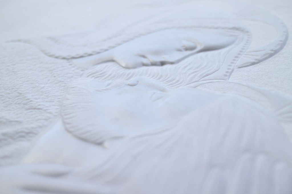 Un primo piano di una coperta bianca con il disegno di una persona sopra.