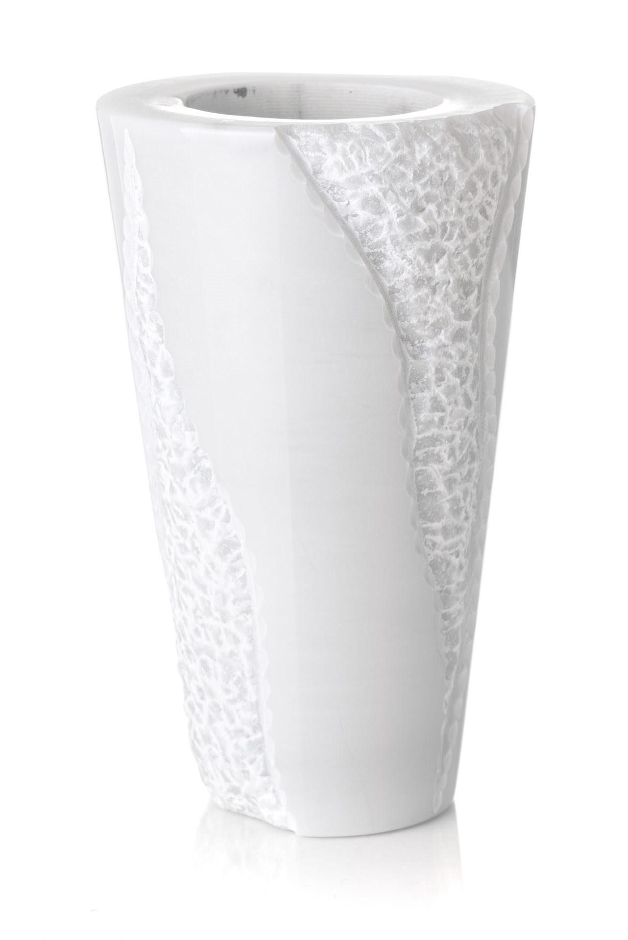 Un vaso bianco con un motivo è su uno sfondo bianco.