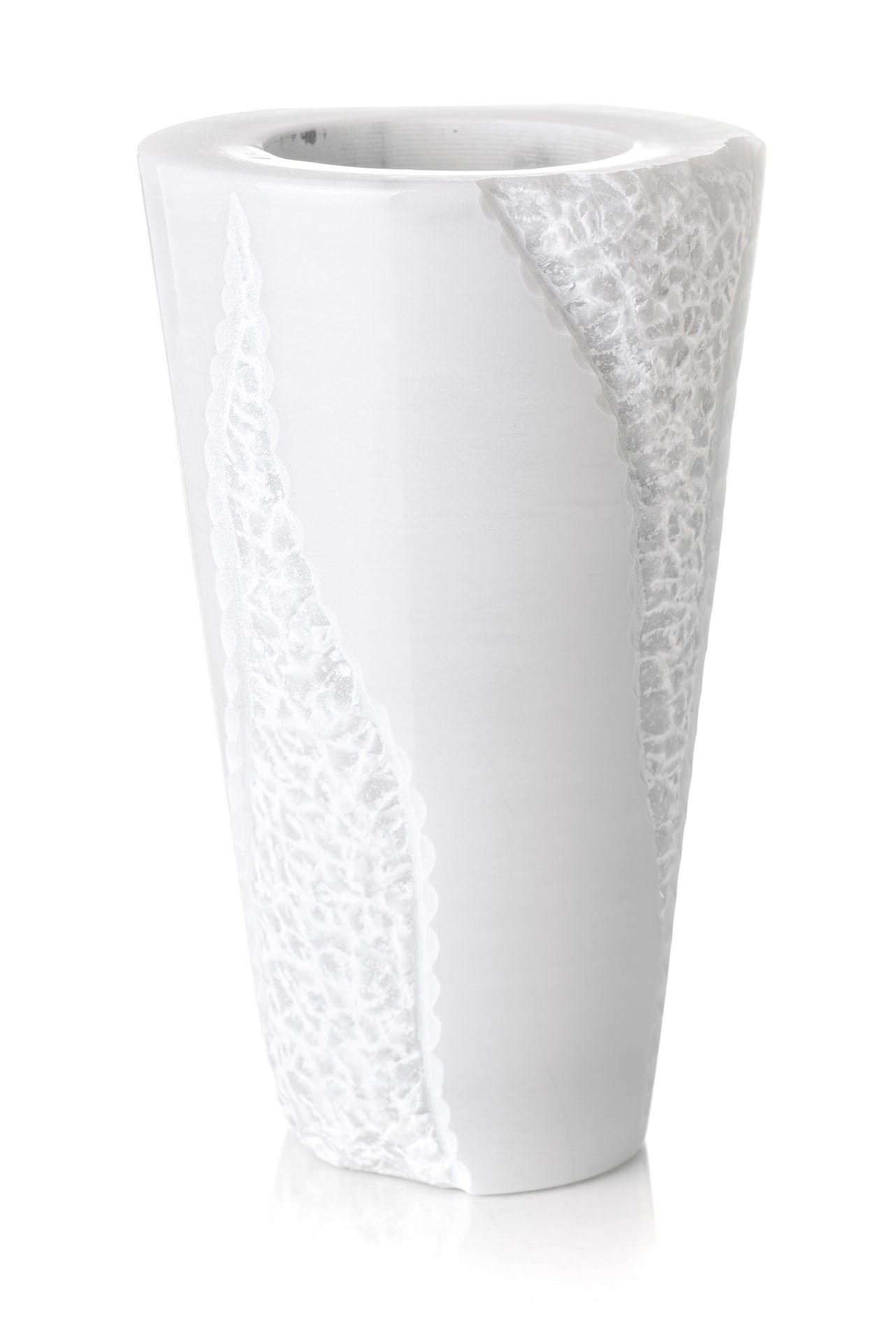 Un vaso bianco con un motivo è su uno sfondo bianco.