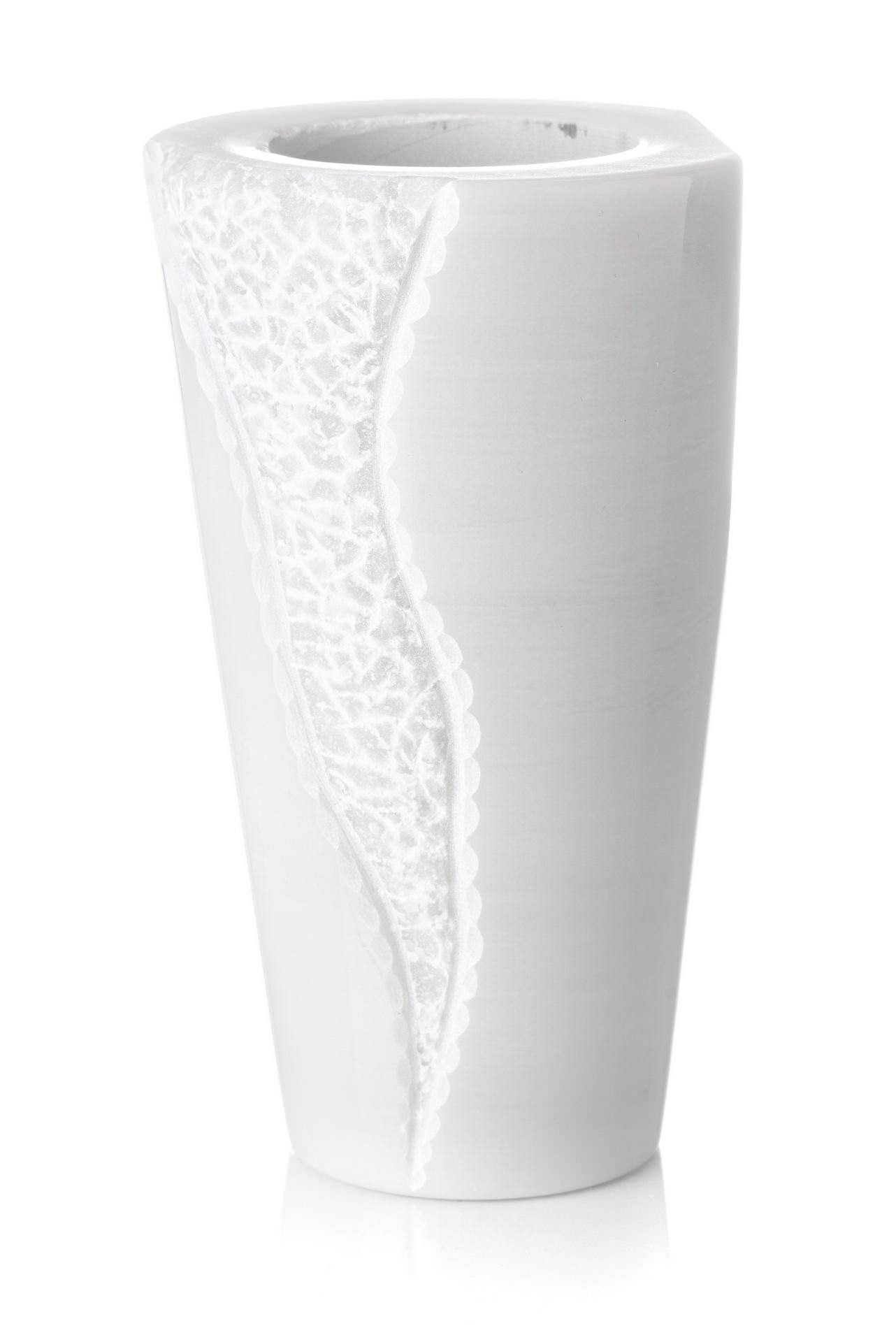 Un vaso bianco con un motivo è su uno sfondo bianco.