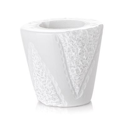 Un vaso bianco con un motivo in pizzo su uno sfondo bianco.