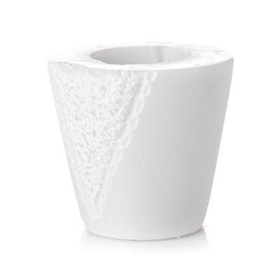 Un vaso bianco con un motivo in pizzo su uno sfondo bianco.