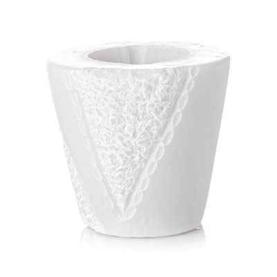 Un vaso bianco con un motivo in pizzo su uno sfondo bianco.