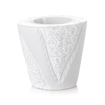 Un vaso bianco con un motivo in pizzo su uno sfondo bianco.