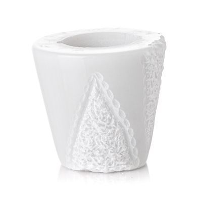 Un vaso bianco con un disegno in pizzo su uno sfondo bianco.