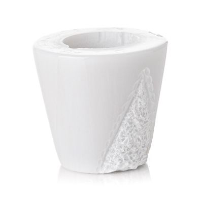 Un portacandele bianco con un disegno in pizzo su uno sfondo bianco.