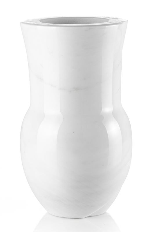 Un vaso bianco è appoggiato su una superficie bianca.