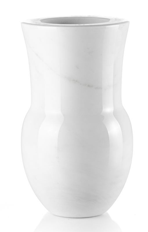 Un vaso bianco è appoggiato su una superficie bianca.