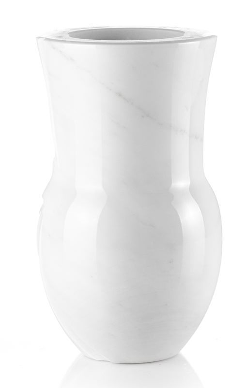Un vaso di marmo bianco è appoggiato su una superficie bianca.