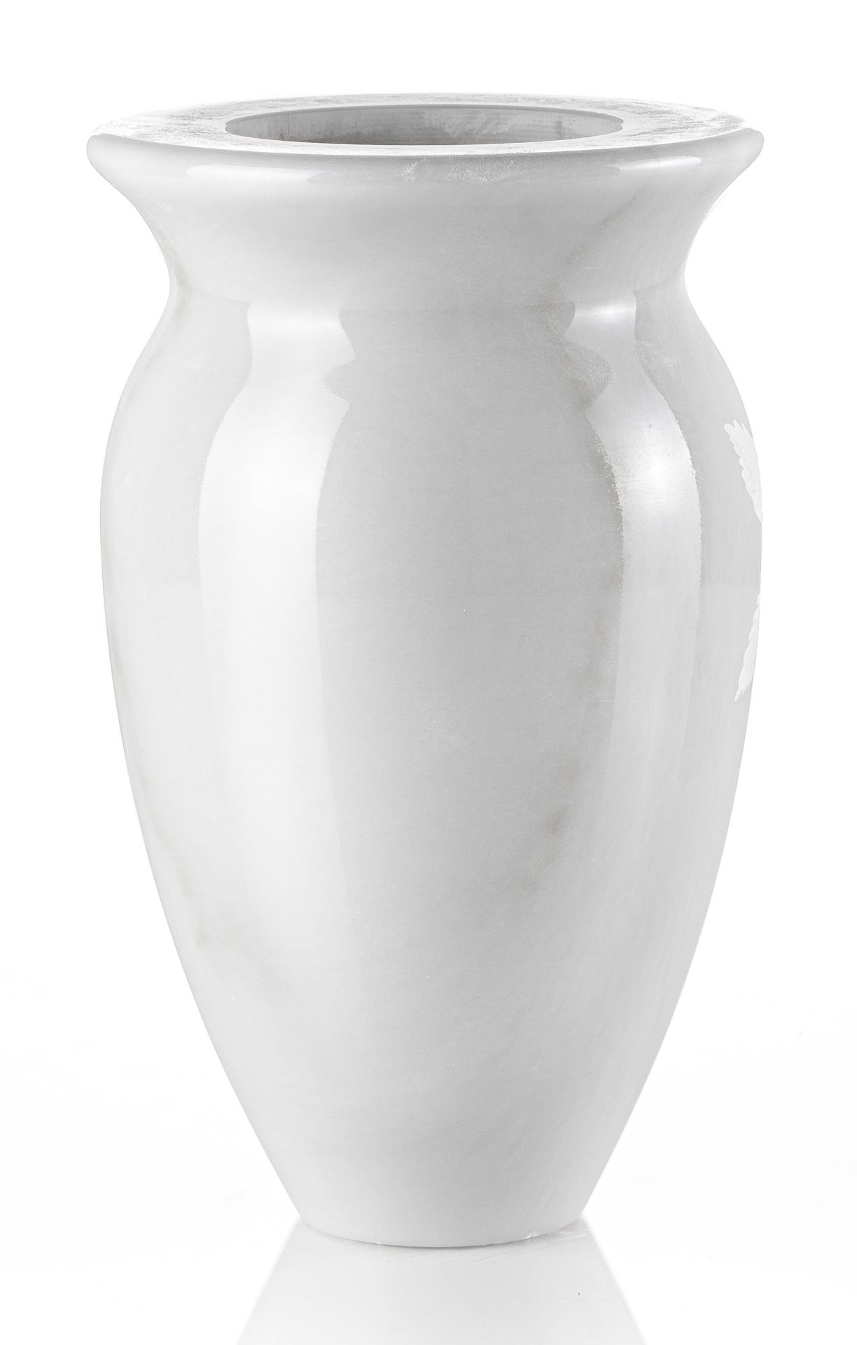 Un vaso bianco è appoggiato su una superficie bianca.