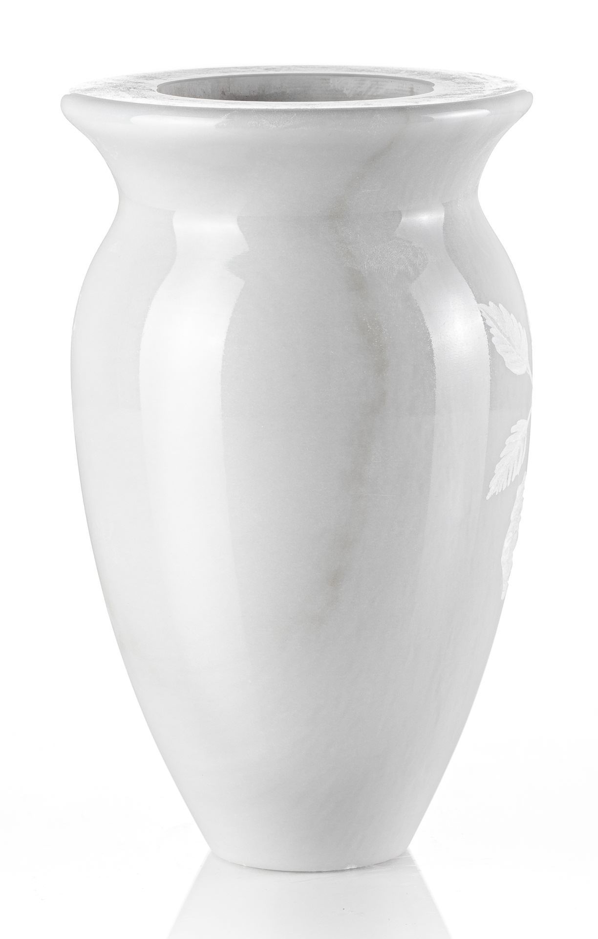 Un vaso bianco è appoggiato su una superficie bianca.