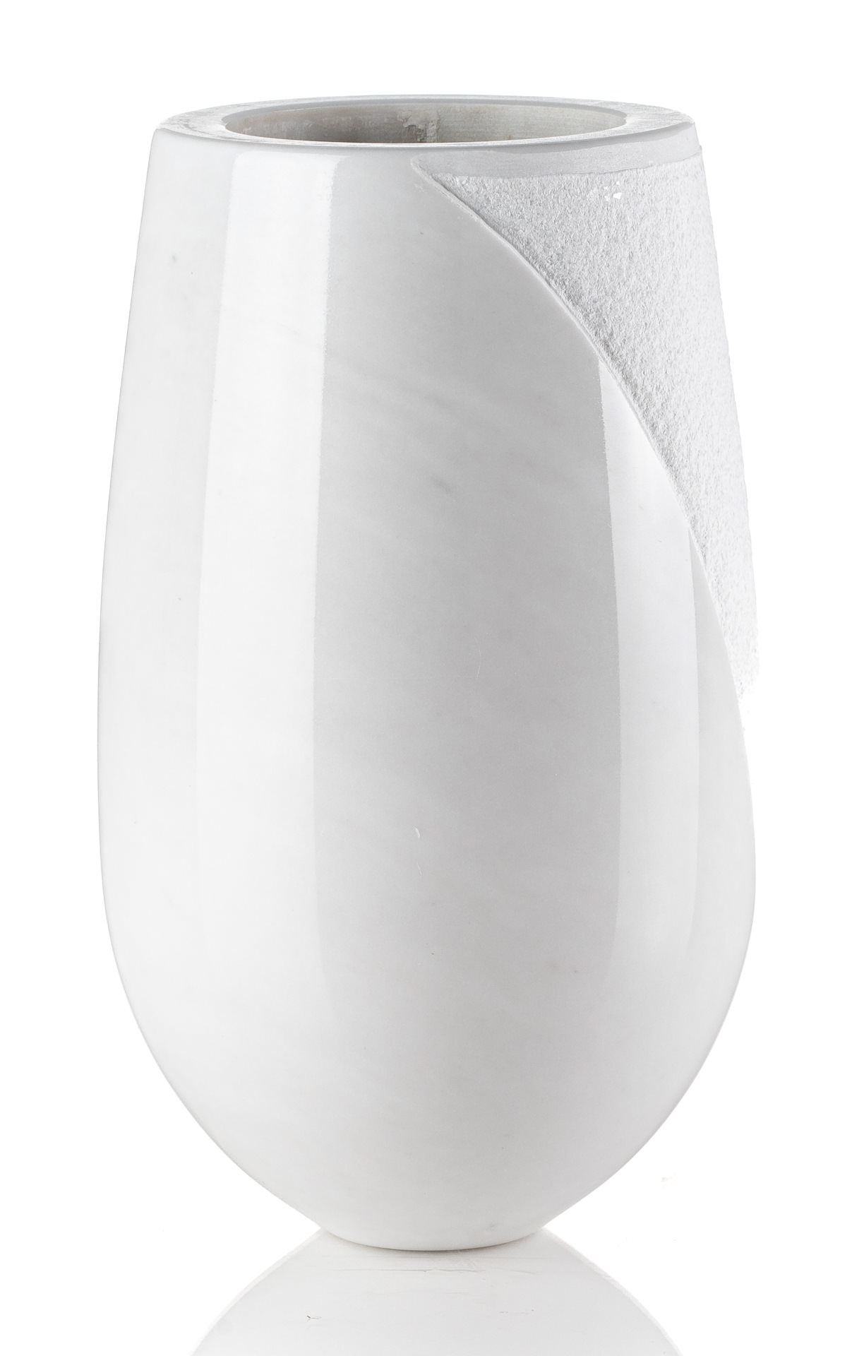 Un vaso bianco è appoggiato su una superficie bianca.