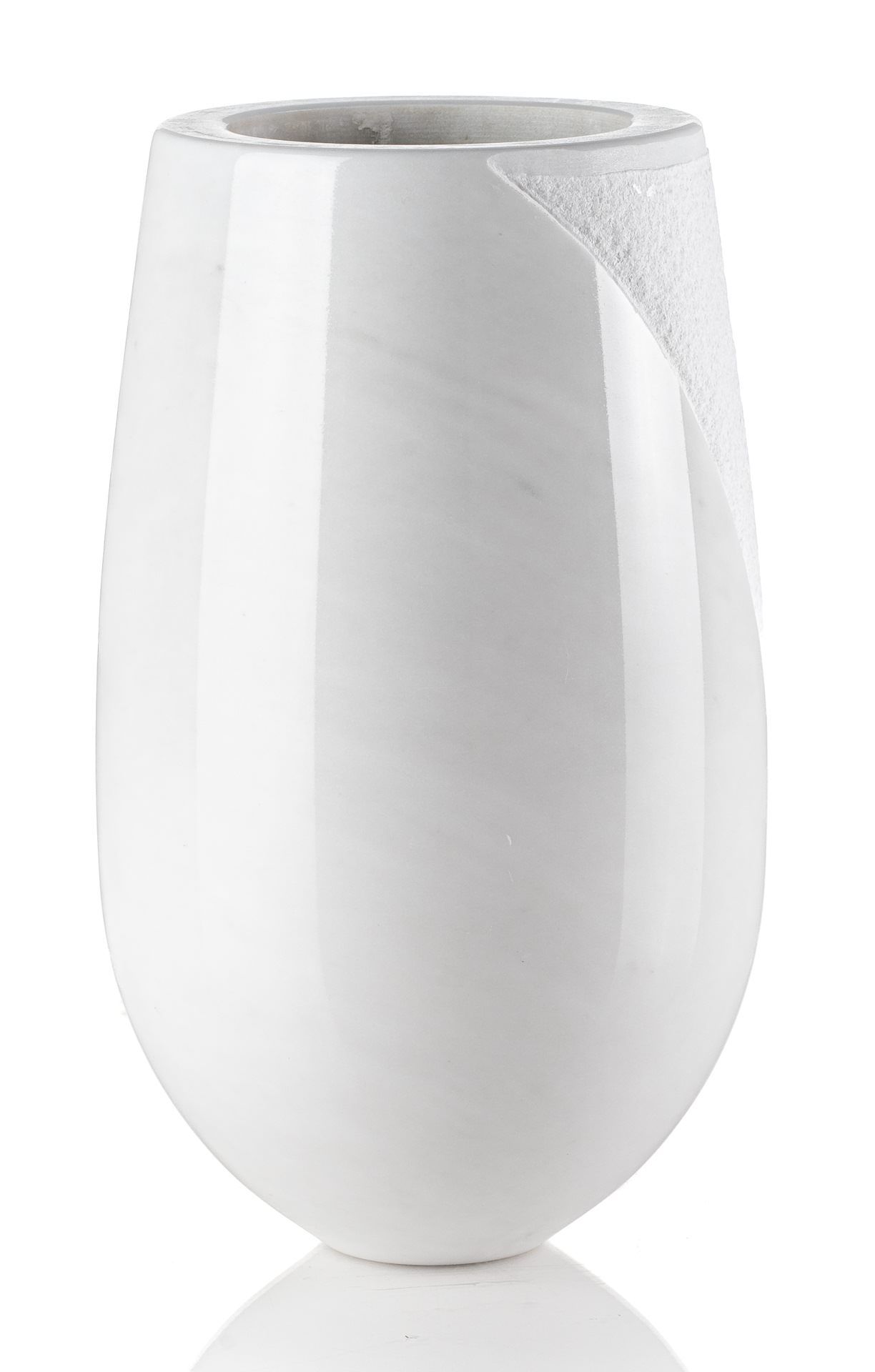 Un vaso bianco è appoggiato su una superficie bianca.