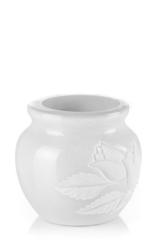 Un vaso bianco con un uccello e delle foglie su uno sfondo bianco.