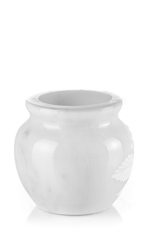 Un vaso di ceramica bianca è appoggiato su una superficie bianca.