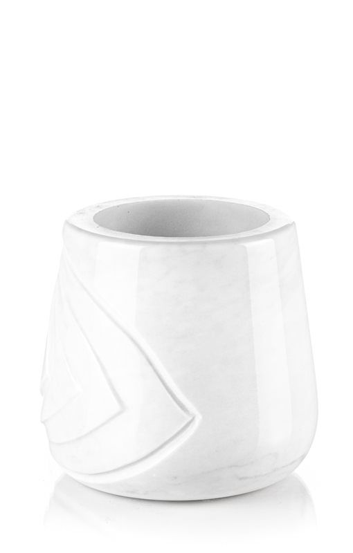 Un vaso bianco con un disegno geometrico è su una superficie bianca.