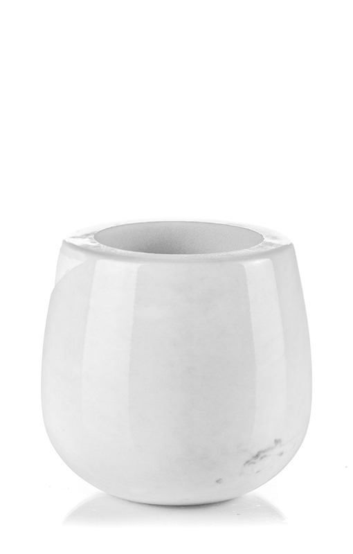 Una ciotola di marmo bianco è appoggiata su una superficie bianca.