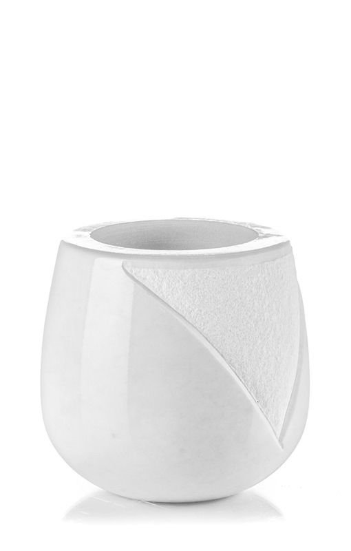 Un vaso di ceramica bianca con un disegno a vortice su uno sfondo bianco.