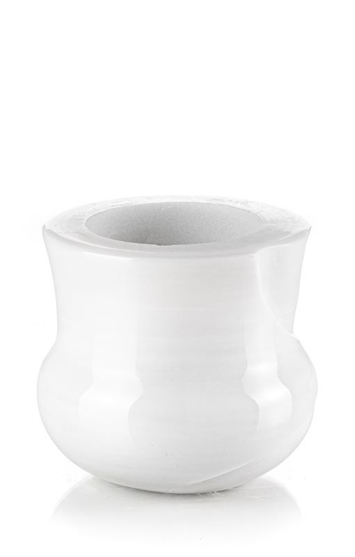 Una ciotola bianca è appoggiata su una superficie bianca.