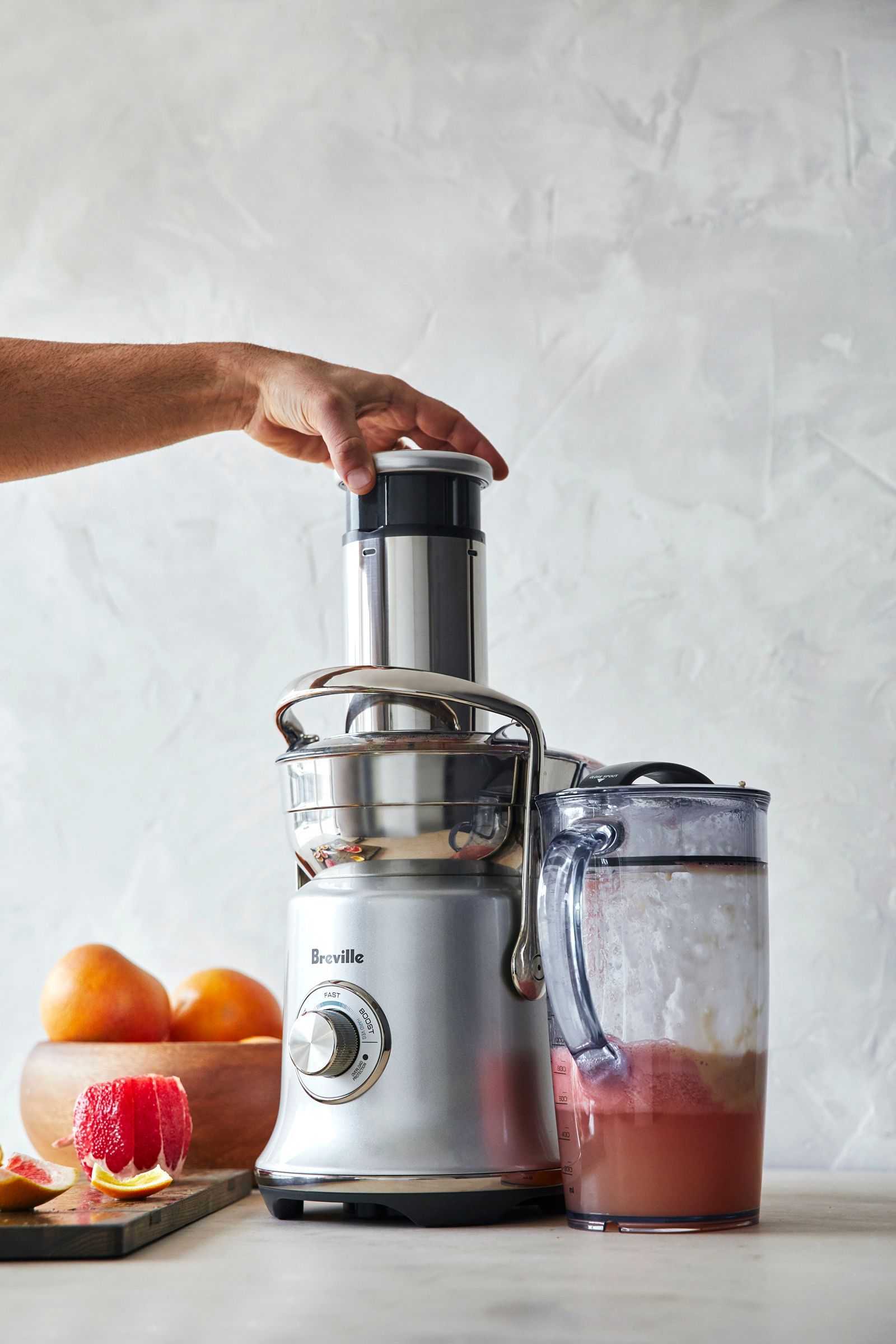 A person is using a juicer to make a smoothie.