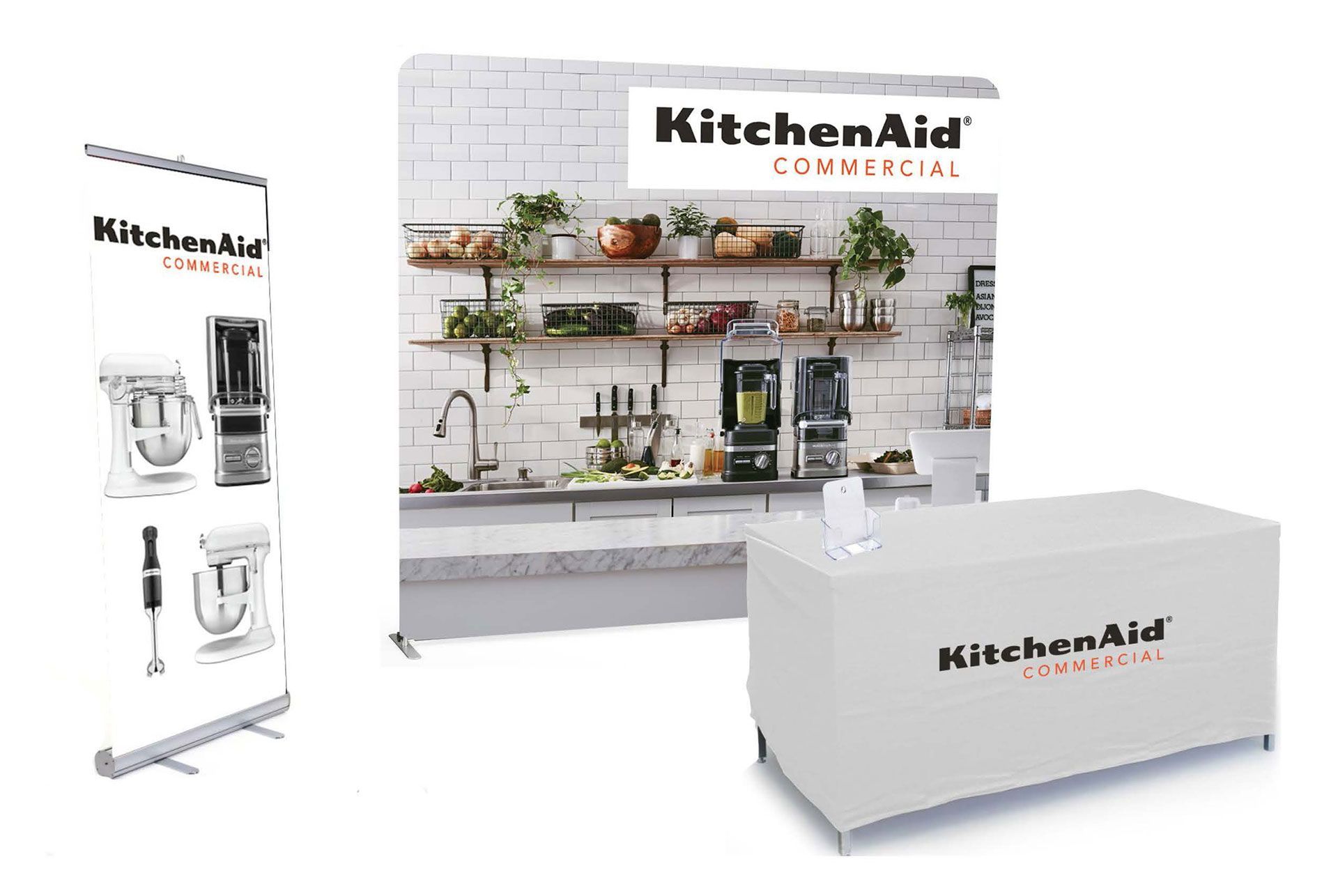 A KitchenAid display with a table and a banner.