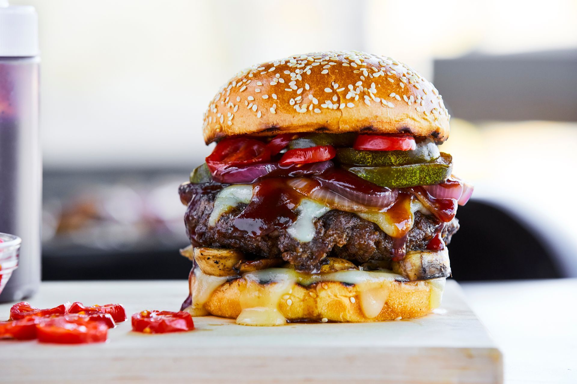 A hamburger is sitting on top of a wooden cutting board.