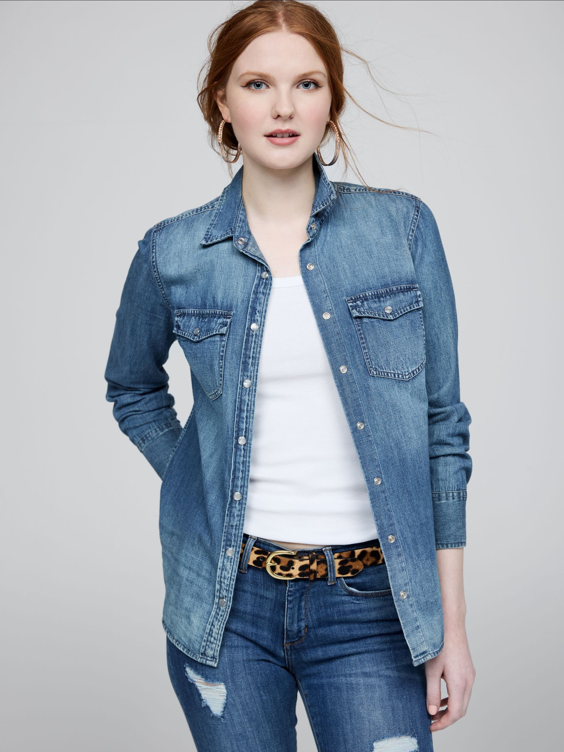 A woman is wearing a denim shirt and jeans