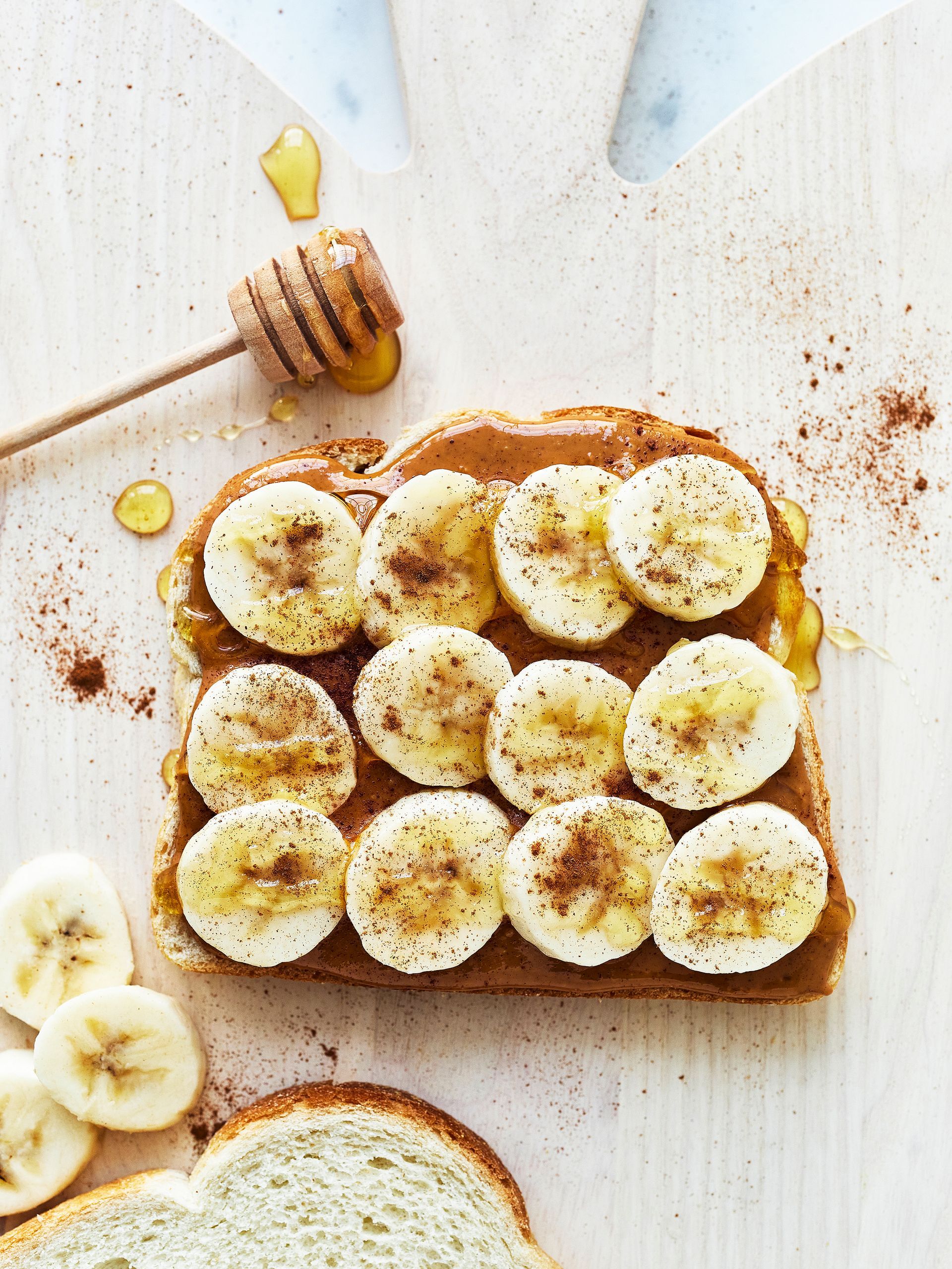 A slice of bread with almond butter and bananas on it.