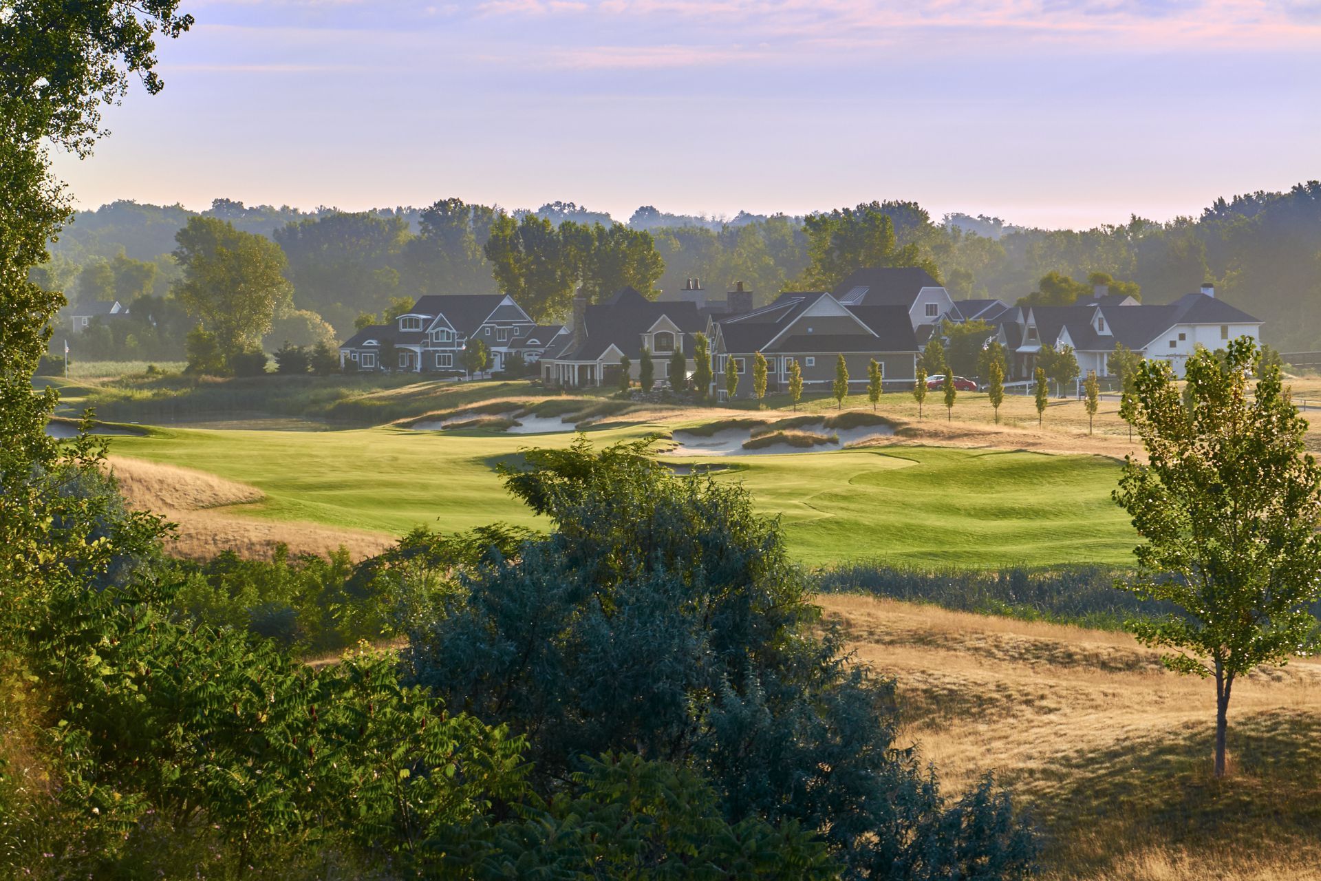 A view of a golf course with houses in the background.