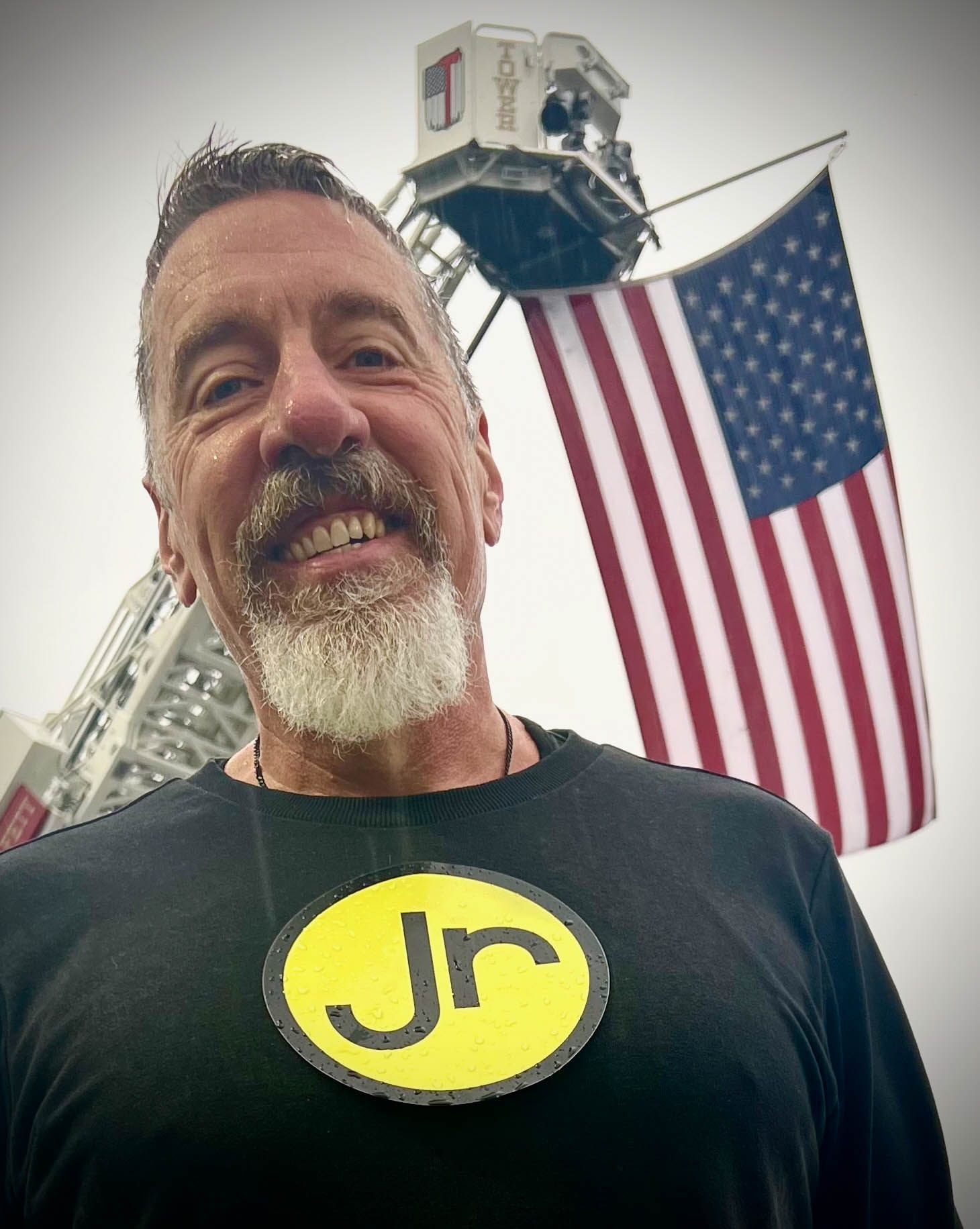A man wearing a black shirt with the letter JR on it