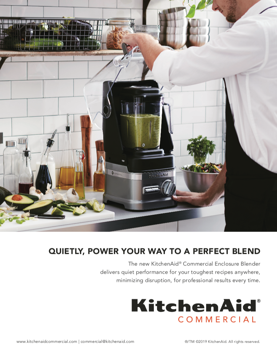 A man is using a kitchenaid commercial blender to make a smoothie.