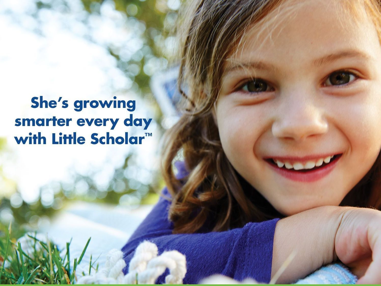 A little girl is smiling with the words she 's growing smarter every day with little scholar