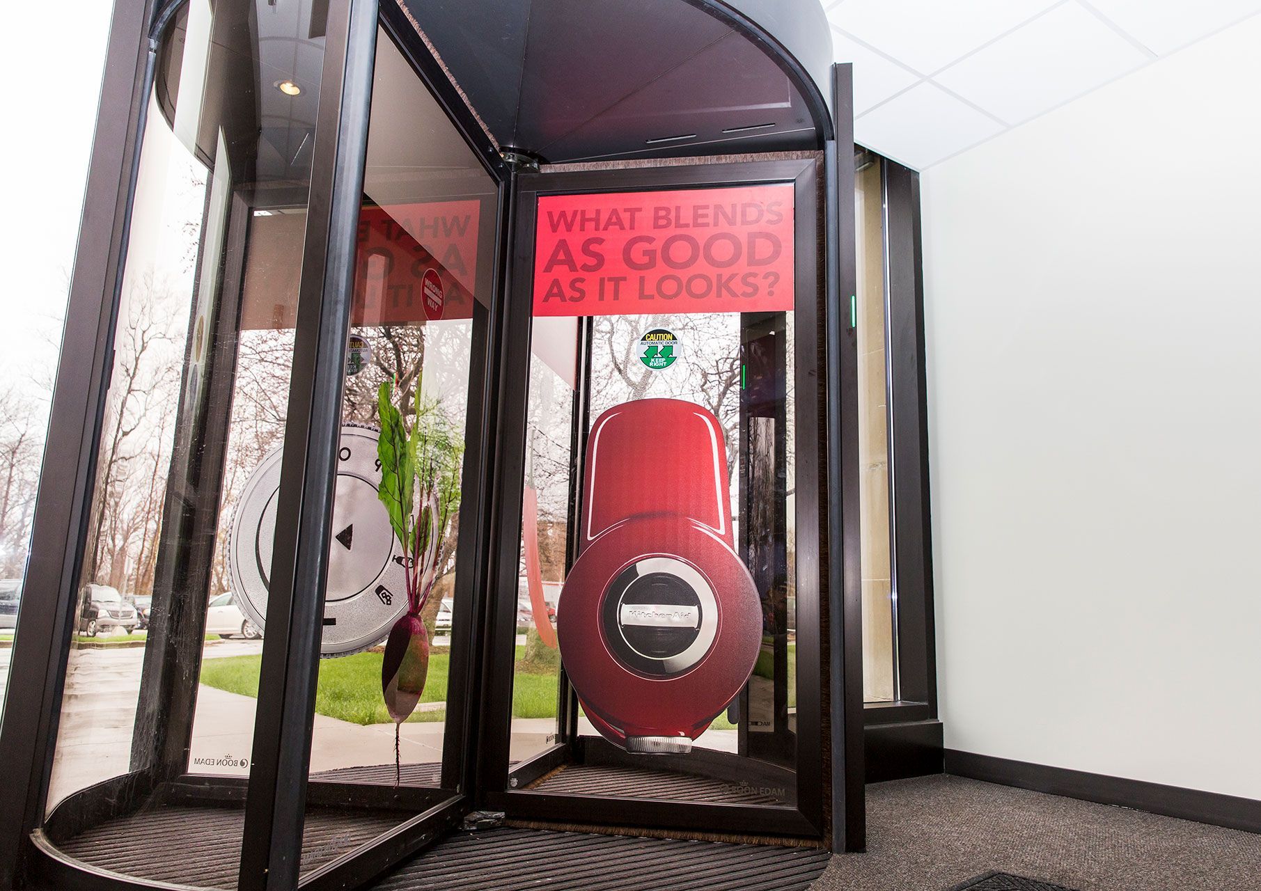 A revolving door with a sign that says what smells as good as it looks