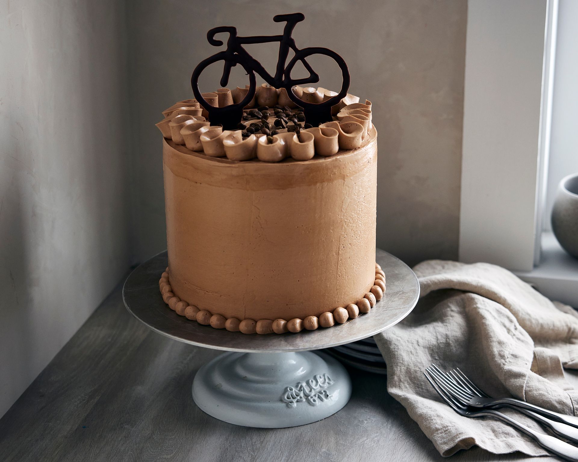 A chocolate cake with a bicycle topper on top of it