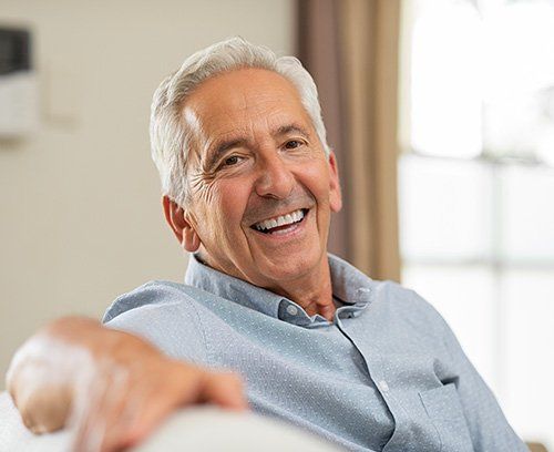Elder man sitting on couch smiling
