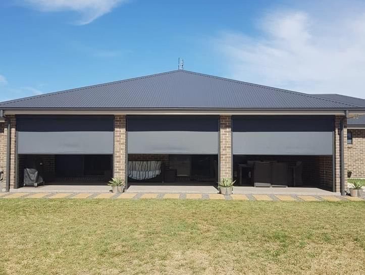 A house with a lot of windows and a lawn in front of it.