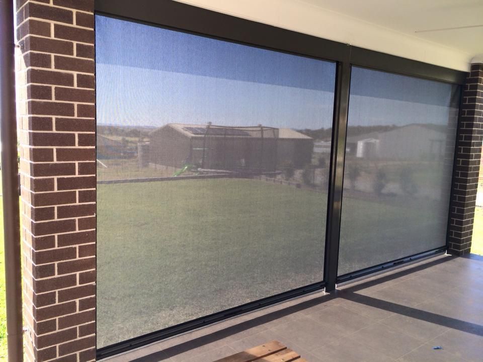 A porch with a lot of windows and a brick wall.