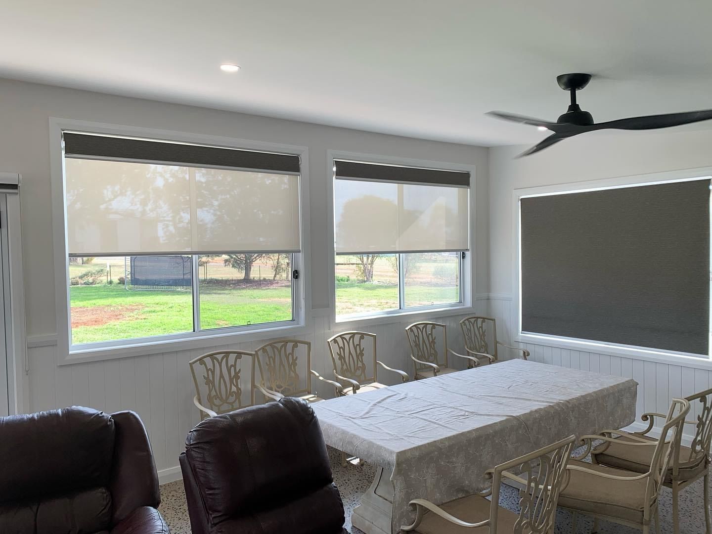A living room with a table and chairs and a ceiling fan.