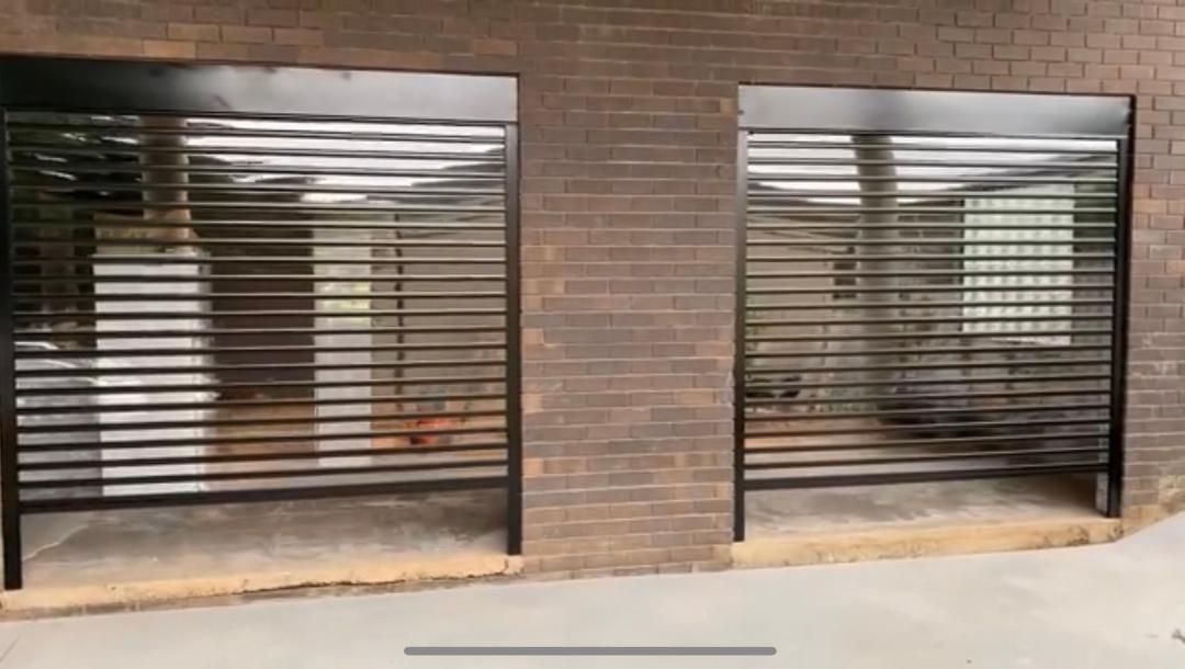 A brick building with a row of metal shutters on the side of it.