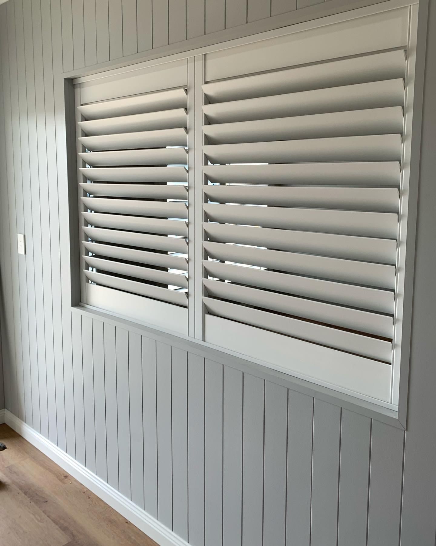 There is a window with shutters on it in a room.