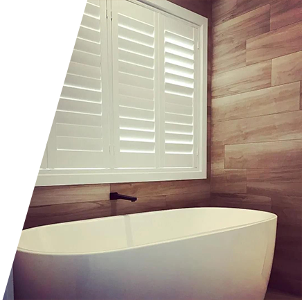 A white window with shutters on it in a room