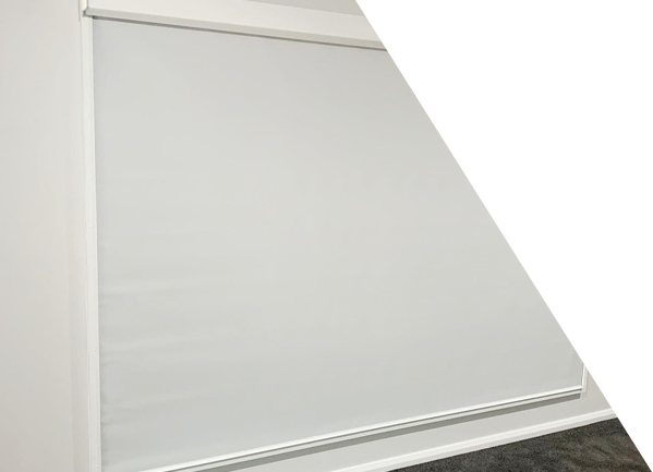 A white roller blind is hanging on a white wall.