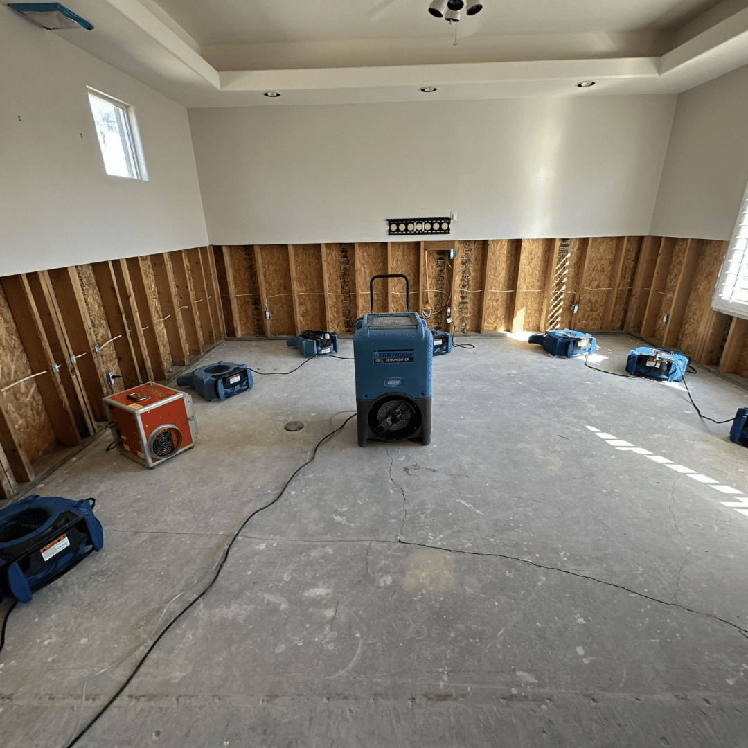 Professional drying equipment and air movers running inside a water damaged Gilbert home. Ideal intro image showing the start of the structural drying and restoration process.