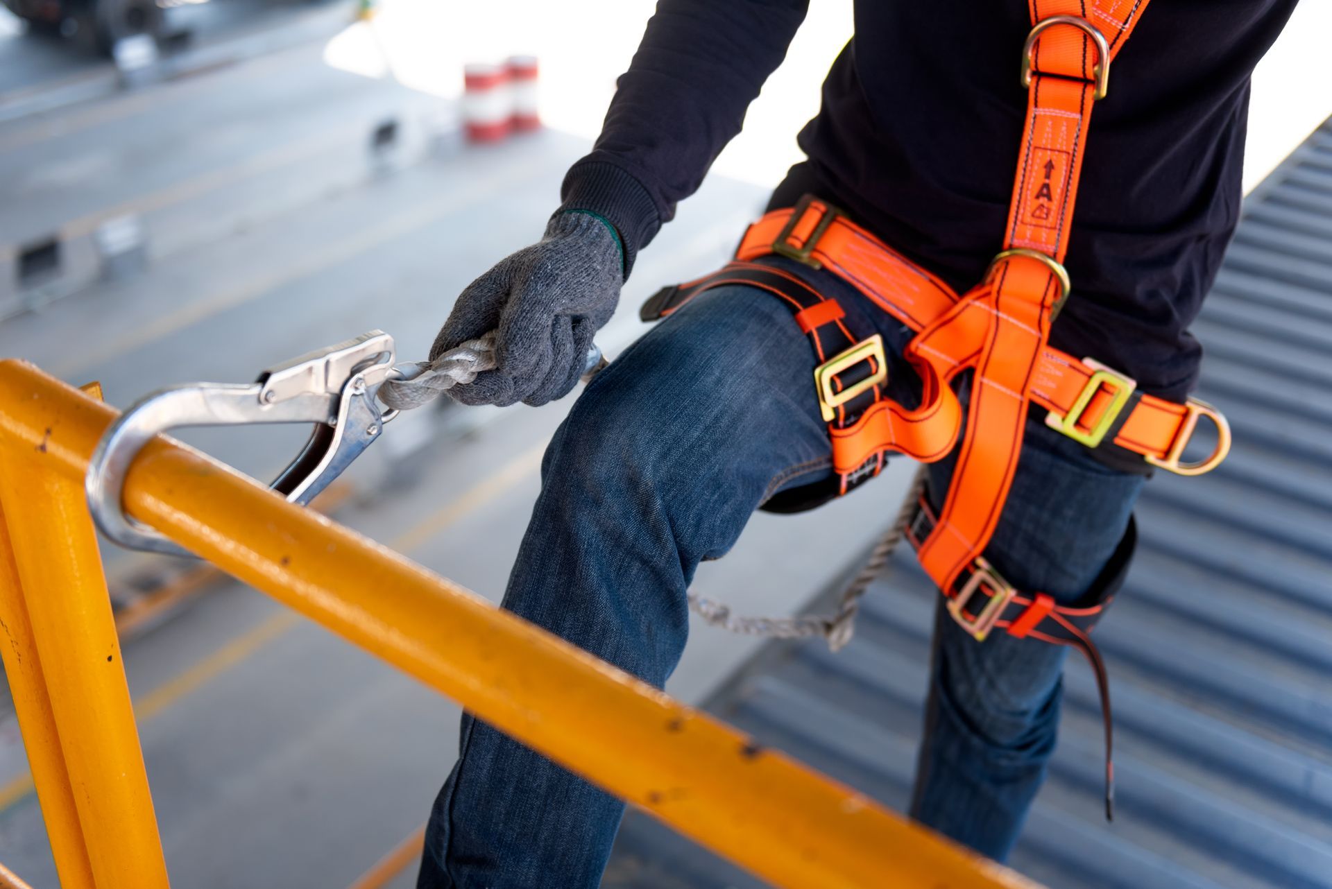 Worker using safety harness clipped to railing.